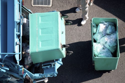 Workers assessing garden waste and preparing removal plan